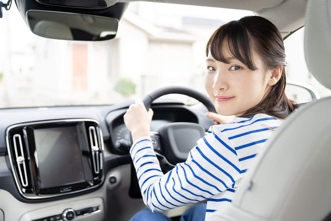 女性が車の運転席で笑顔の様子