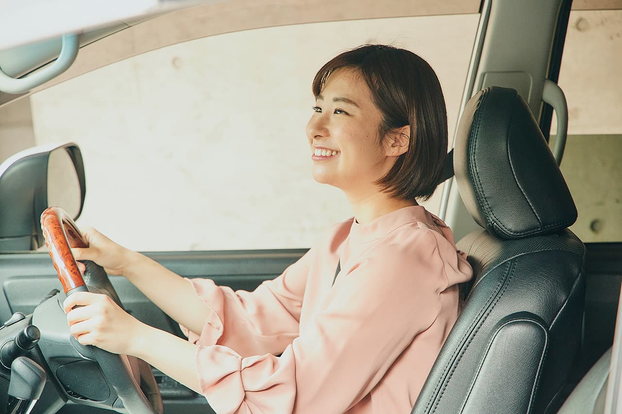 車の運転をしながら笑顔の女性