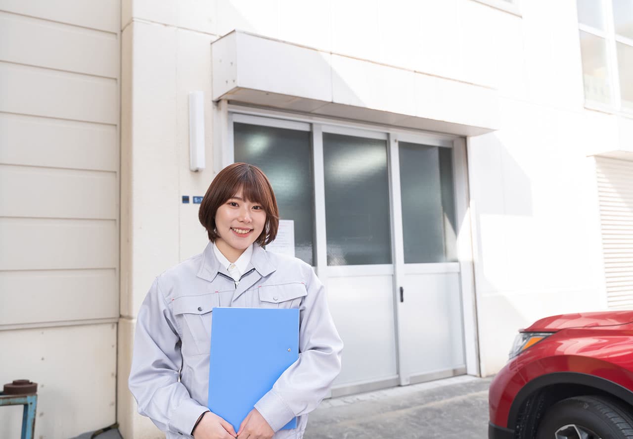 建物の前でファイルを持っている女性