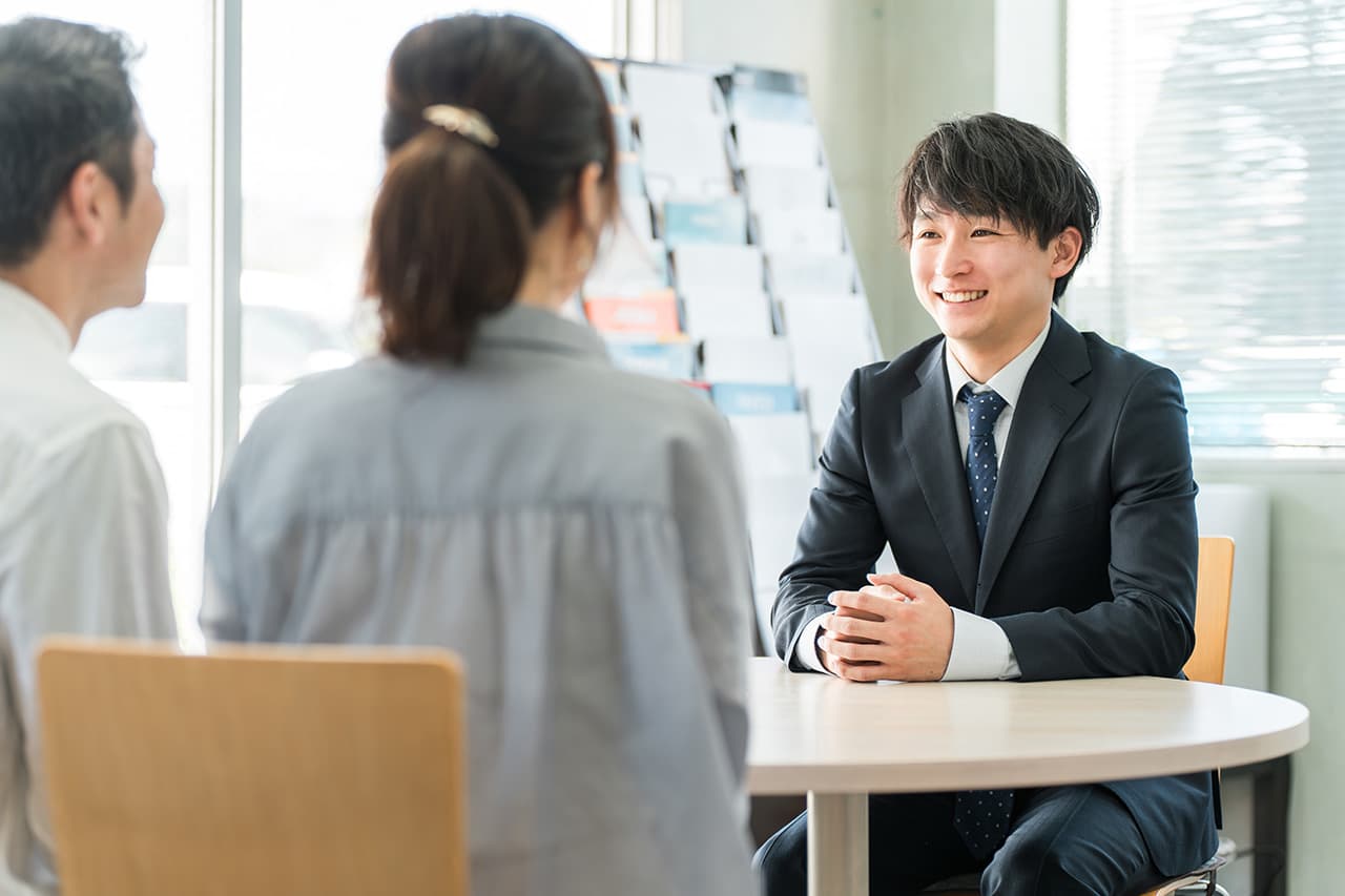 接客する若い男性とご夫婦のお客様